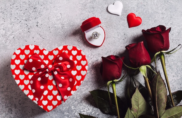 Valentinstag heirate mich Ehering im Kasten mit Blumenstrauß der roten Rosen und Geschenkboxherzen