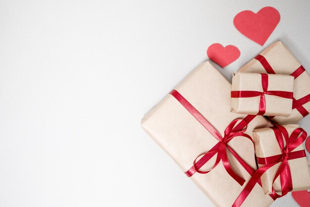 Valentinstag Hintergrund mit Geschenkboxen rotes Band und Herzen auf weißem Hintergrund Draufsicht flach liegen