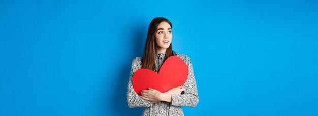 Valentinstag hoffnungsvolles Mädchen, das von einem Seelenverwandten träumt, der vor Aufregung auf den leeren Raum blickt, huggi