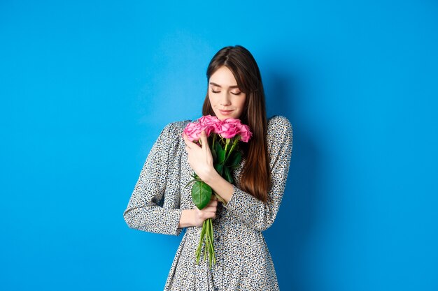 Valentinstag Konzept leidenschaftliche und romantische junge Frau umarmt Bouquet von Geschenkrosen, die nach Fl...