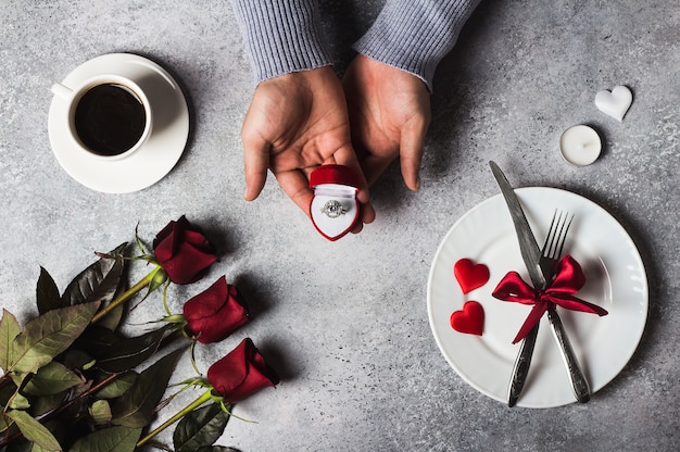 Valentinstag romantisches Abendessen Gedeck Mann Hand Verlobungsring halten