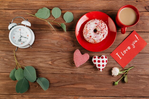 Valentinstagdekorationen nahe Frühstück mit Donut