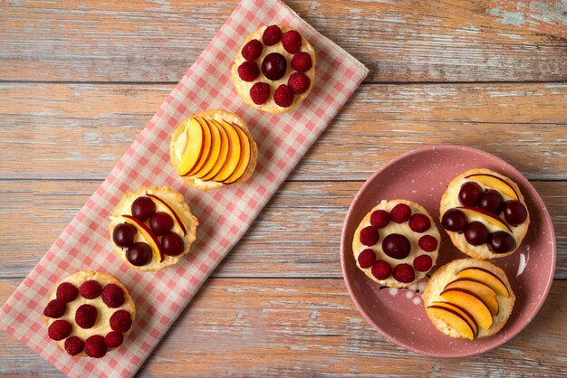 Vanille-Cupcakes mit Sommerbeerenfrüchten auf dem rosa Handtuch