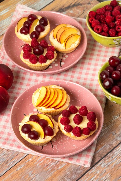 Vanille Cupcakes mit Sommerbeerenfrüchten auf den rosa Platten