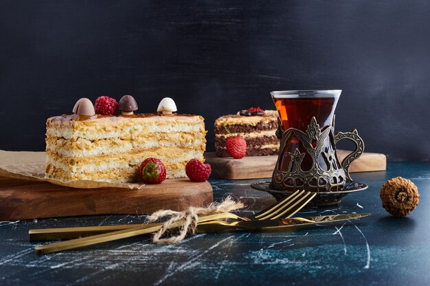 Vanille-Ganache-Kuchenscheibe mit einem Glas Tee.