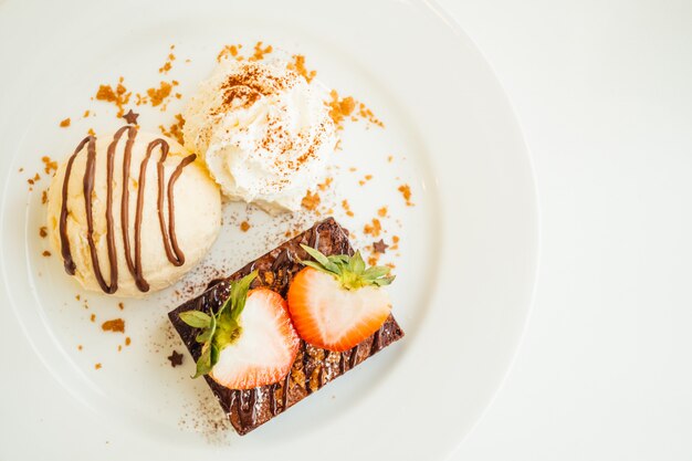 Vanilleeis mit Schokoladenschokoladenkuchenkuchen mit Erdbeere an der Spitze