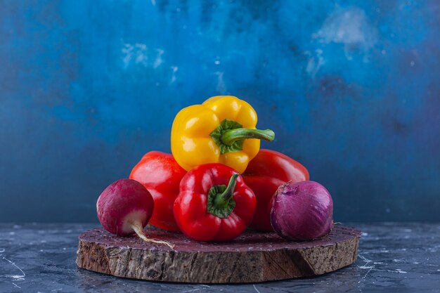 Variation von Paprika und Radieschen in verschiedenen Farben auf Holzstück