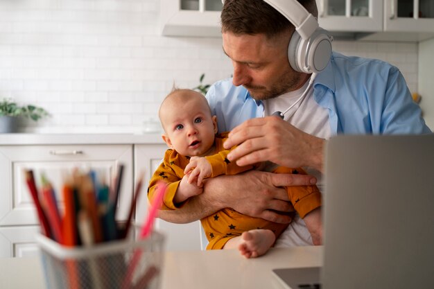 Vater arbeitet von zu Hause aus und versucht, das Familienleben mit Kind und Beruf in Einklang zu bringen