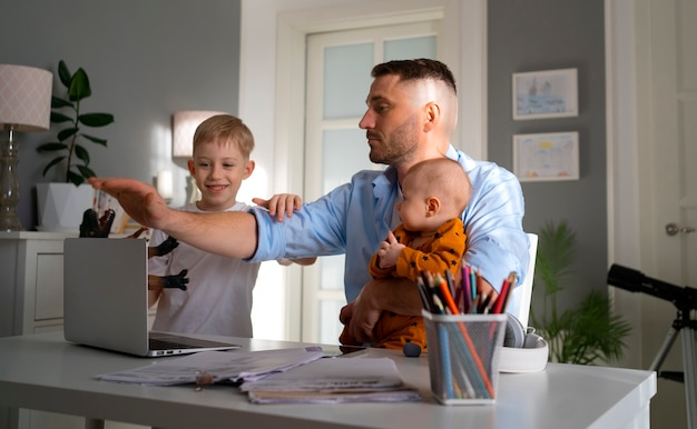 Vater arbeitet von zu Hause aus und versucht, das Familienleben mit Kind und Beruf in Einklang zu bringen