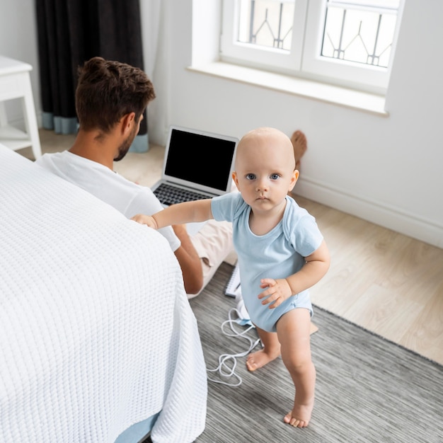 Kostenloses Foto vater arbeitet von zu hause aus während der quarantäne mit kind