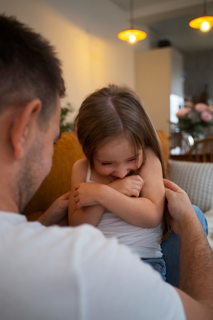 Vater bringt seine Tochter zum Lachen, indem er sie kitzelt