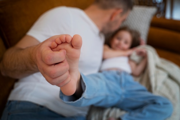 Vater bringt seine Tochter zum Lachen, indem er sie kitzelt