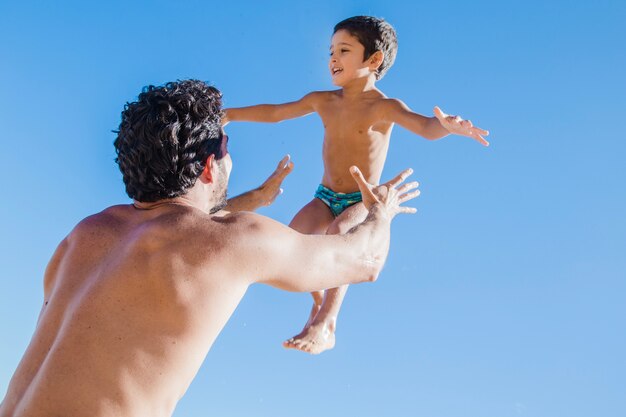 Vater, der den Sohn in die Luft werft