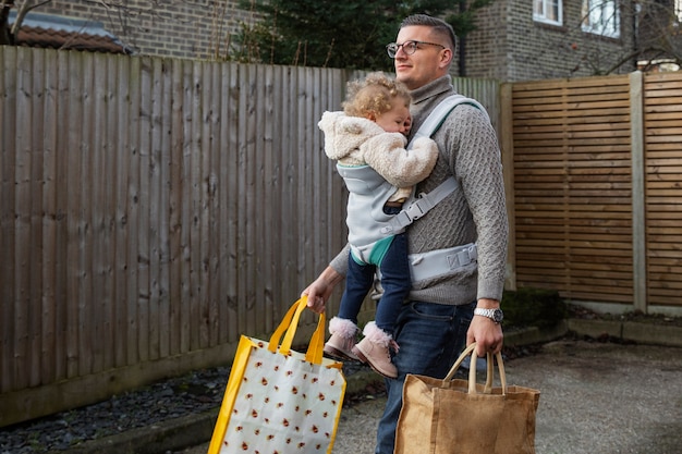 Vater hält Baby in Seitenansicht der Trage