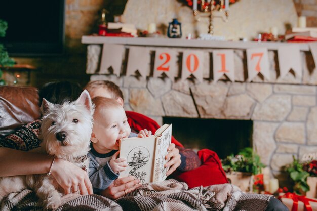 Vater hält ein Buch, wo das Baby lehnt