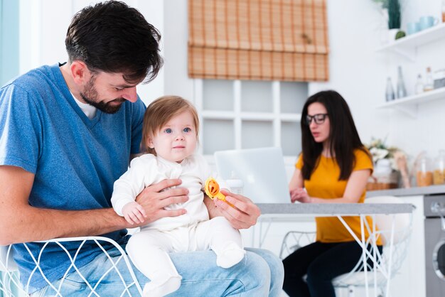 Vater hält Kind in der Küche