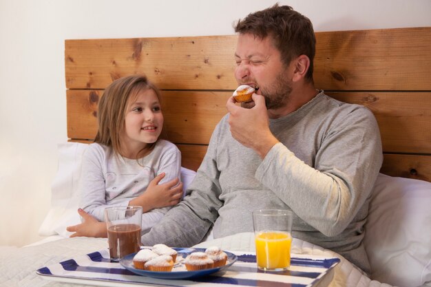 Vater isst einen kleinen Kuchen neben seiner Tochter