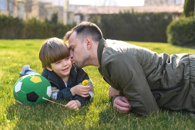 Vater küsst Sohn draußen