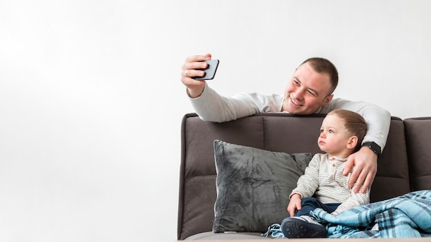 Kostenloses Foto vater macht ein selfie mit seinem baby