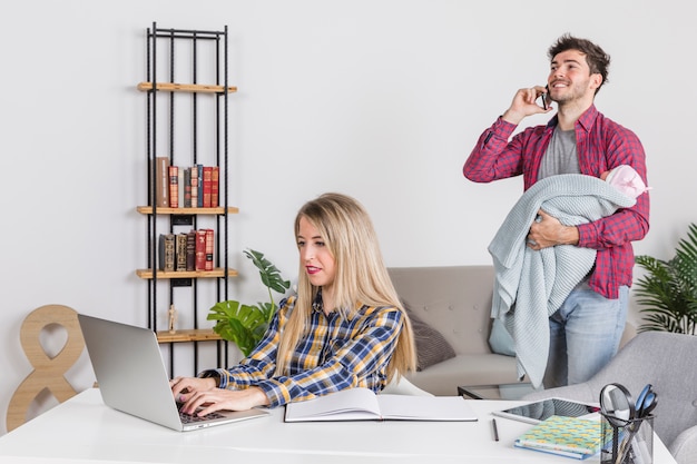 Vater mit dem Baby, das am Telefon spricht