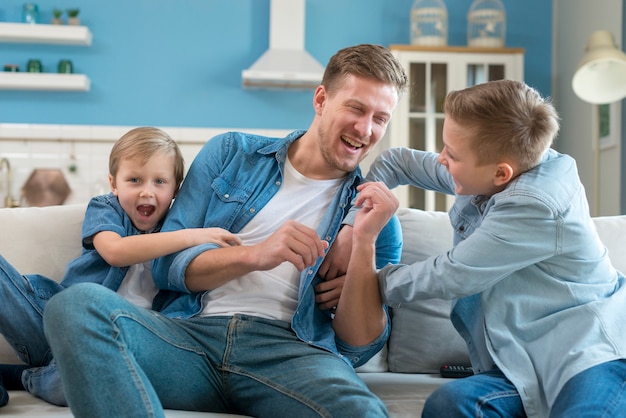 Vater mit Geschwistern, die drinnen spielen