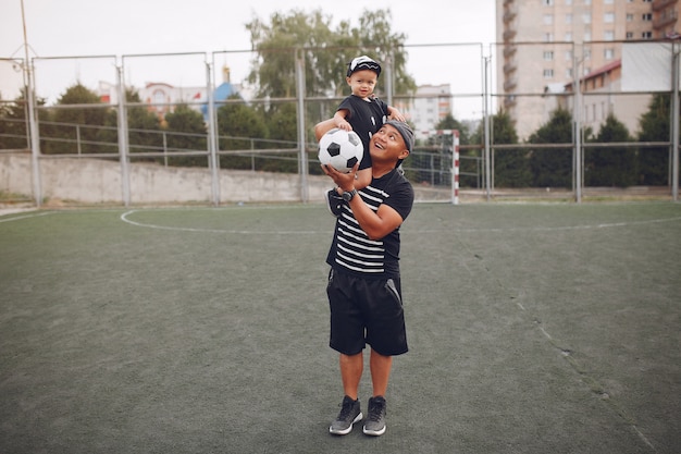 Vater mit kleinem Sohn, der Fußball spielt