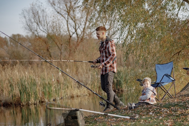 Vater mit kleinem Sohn in der Nähe des Flusses an einem Morgen beim Angeln