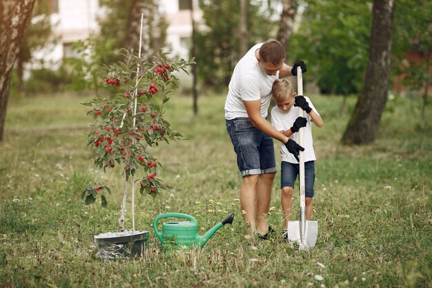 Vater mit kleinem Sohn pflanzen einen Baum auf einem Yard