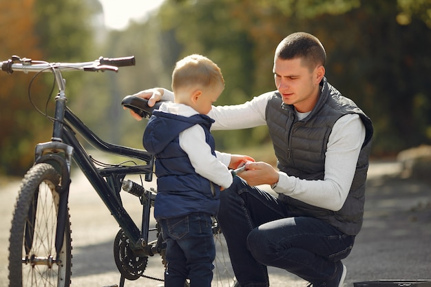 Vater mit Sohn reparieren das Fahrrad in einem Park