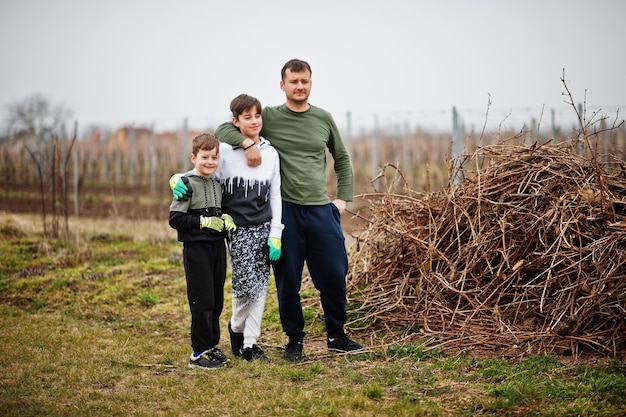 Vater mit zwei Söhnen, die im Weinberg arbeiten