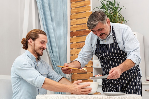 Vater serviert Sohn mit leckerem Essen