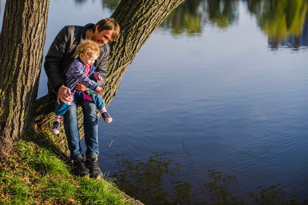 Vater sitzt auf einem Koffer mit seinem Sohn