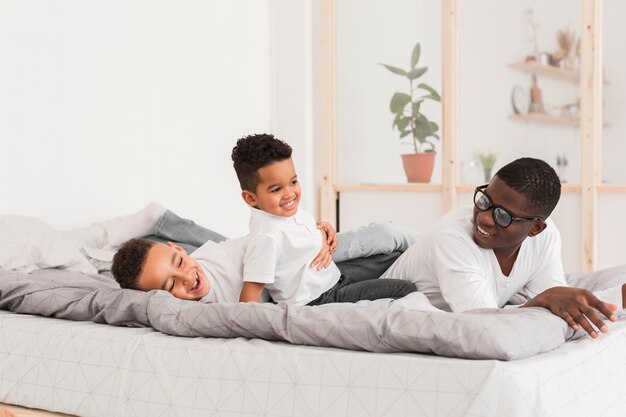 Vater spielt mit seinen Söhnen im Bett