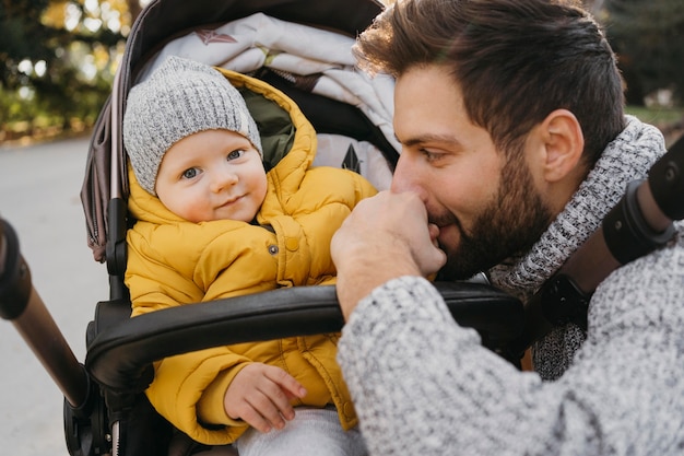 Vater und Kind im Kinderwagen draußen in der Natur