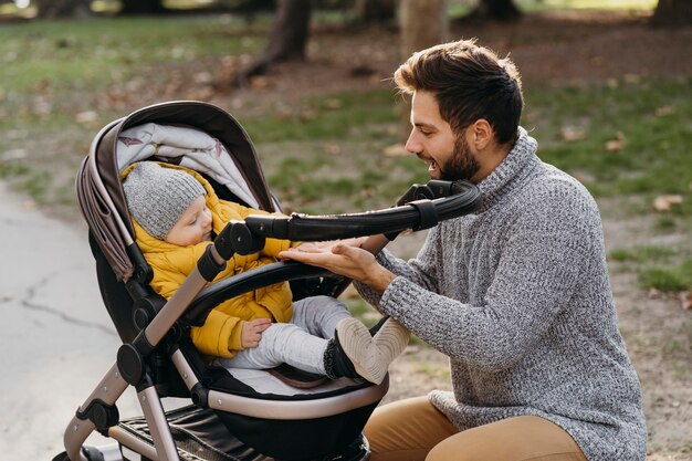 Vater und Kind im Kinderwagen im Freien in der Natur