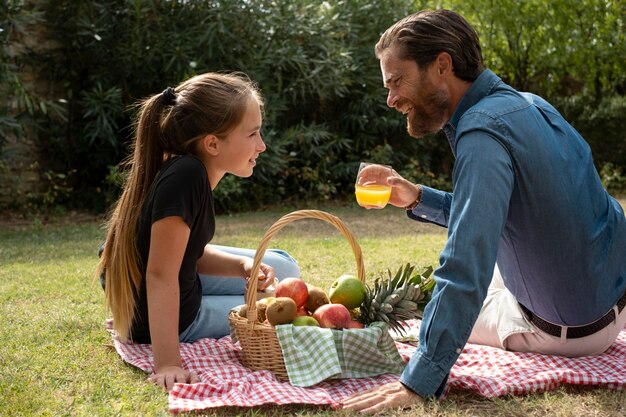 Vater und Kind mit mittlerem Schuss beim Picknick