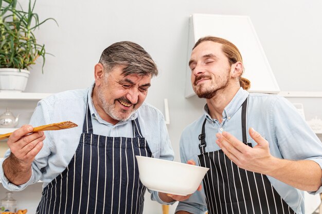 Vater und lustiger Sohn, die einen Teller schmecken