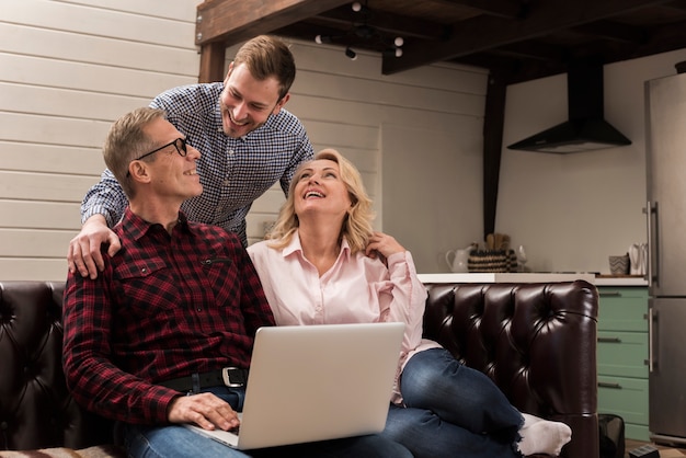 Vater und Mutter auf Sofa mit Laptop und Sohn