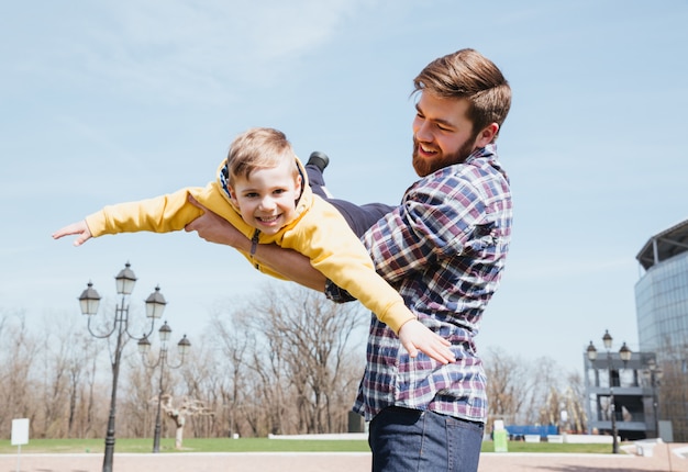 Vater und sein kleiner Sohn spielen zusammen in einem Park