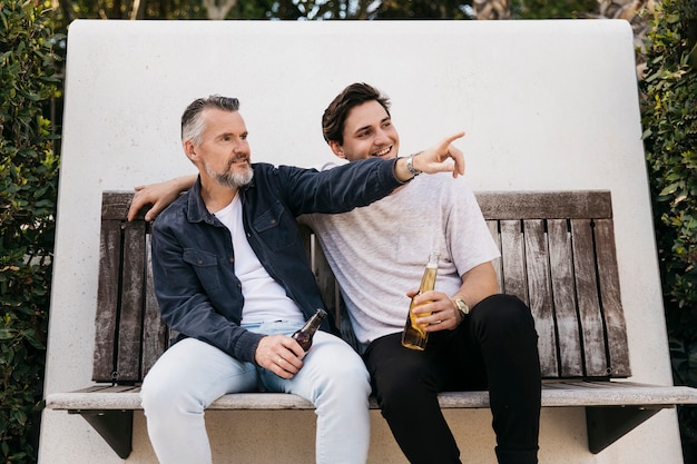 Kostenloses Foto vater und sohn auf bank mit bier