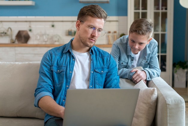 Kostenloses Foto vater und sohn beobachten den laptop