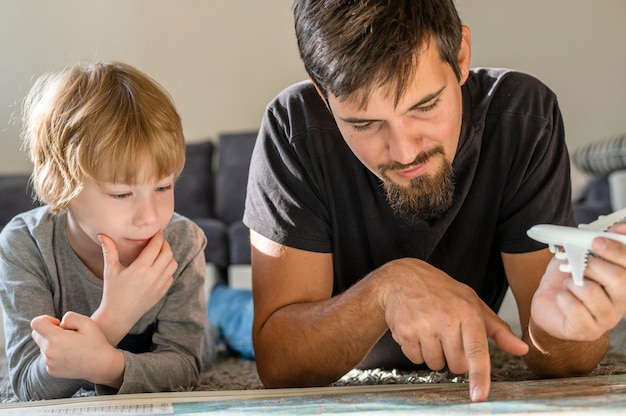 Vater und Sohn betrachten Karte zusammen zu Hause