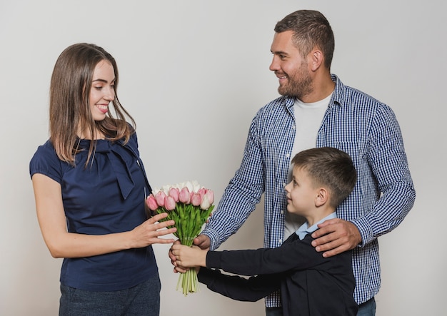 Vater und Sohn, die der Mutter Blumen geben