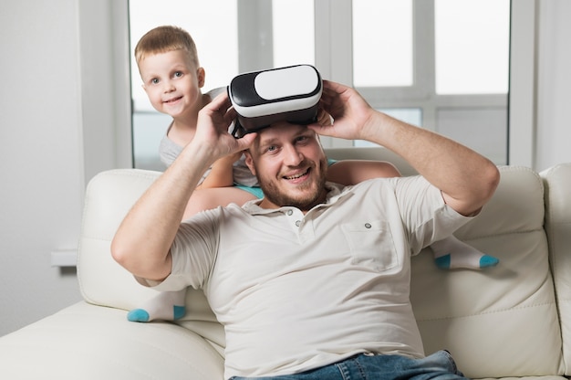 Vater und Sohn, die mit vr Kopfhörer spielen