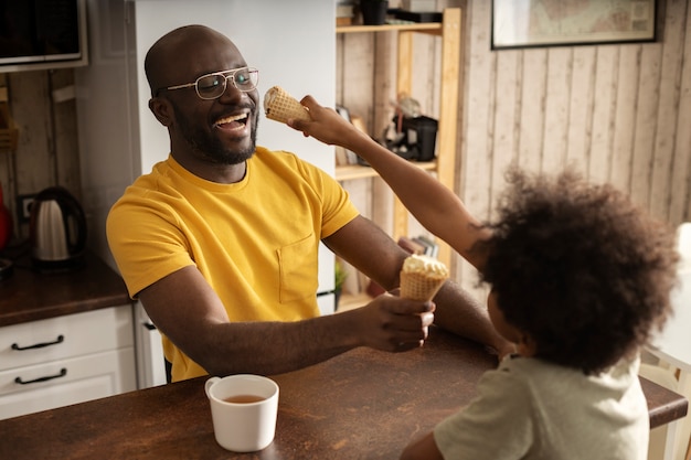 Kostenloses Foto vater und sohn essen gemeinsam eis in der küche