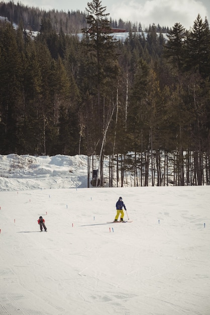 Vater und Sohn fahren auf schneebedeckten Alpen Ski