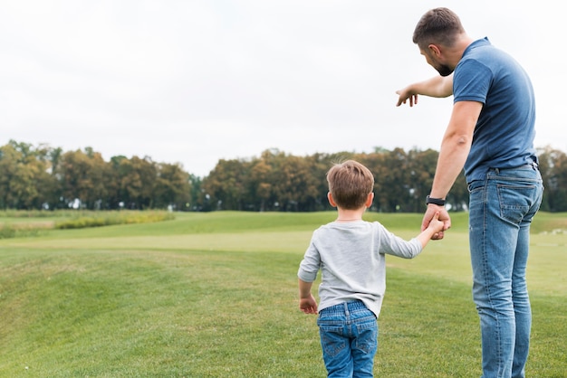 Vater und Sohn halten Hände von hinten Schuss