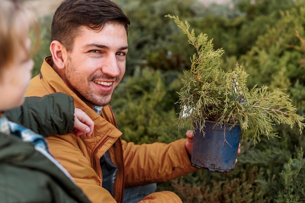 Kostenloses Foto vater und sohn kaufen zusammen einen baum