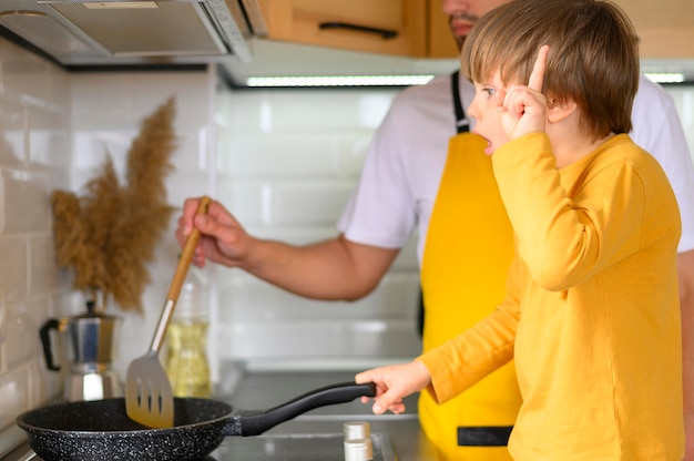 Vater und Sohn kochen in einer Pfanne