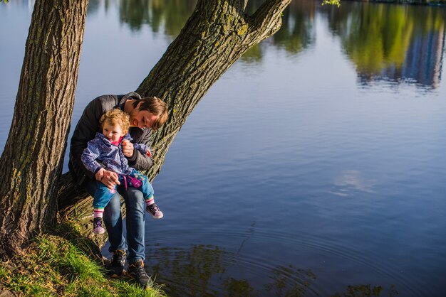 Vater und Sohn sitzen auf einem Stamm im Park